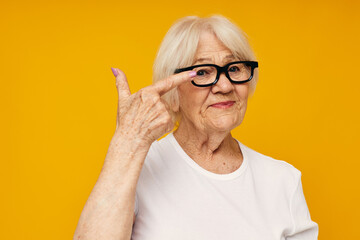 Photo of retired old lady in casual t-shirt and glasses yellow background