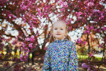 Adorable three year old girl enjoying sunny spring day in Park of Sceaux near Paris, France