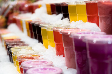 Colorful assortment smoothies on the Boqueria Market stalls in Barcelona waiting for tourists