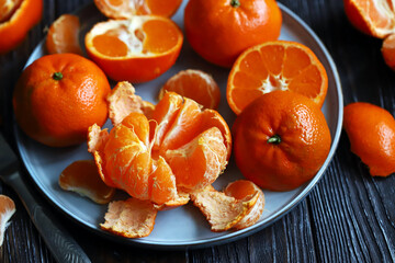Fresh tangerines on a dark wooden background. Citrus.