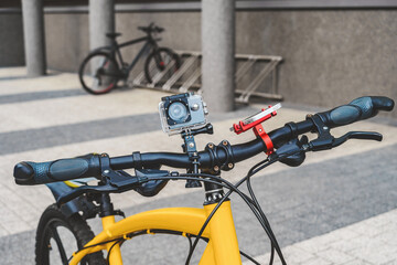 Fototapeta na wymiar A bike with an action camera and a phone on the city.