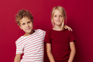 Portrait of cute children good mood standing next to posing on colored background