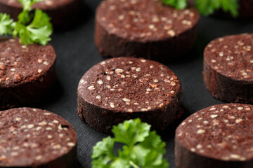 Raw Black Pudding with parsley on rustic stone board