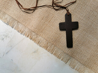 A wooden Christian cross on white old background. Christianity Concept. Flat lay. Copy space.