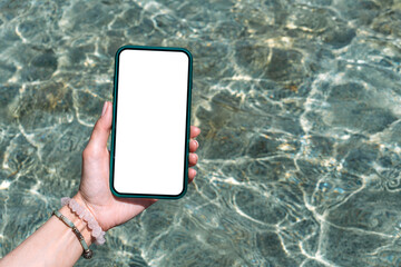 Smartphone mockup in girl's hand. Against the backdrop of clean water in the pool.