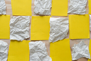 yellow and crumpled paper checkered pattern on wood