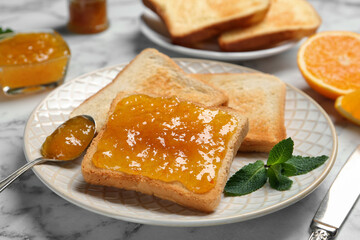 Delicious toasts with jam and mint on white marble table, closeup