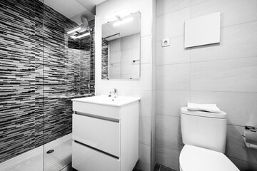 Bathroom with white furniture and white sink tiles, gray tiled wall and frameless mirror