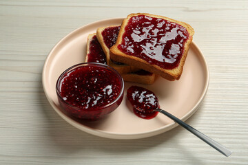 Delicious toasts with jam served on white wooden table