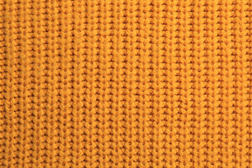 Beautiful orange knitted fabric as background, top view