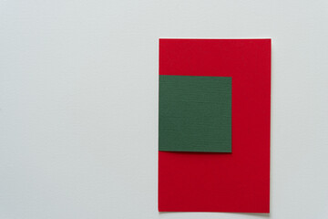 red and green paper shapes on a light background