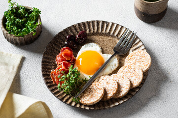 Romantic Breakfast on Women's Day - fried eggs in the shape of a heart and olives. Healthy breakfast. Rice cakes with eggs and hamon. Romantic breakfast. Top view.