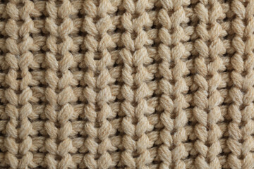 Beautiful beige knitted fabric as background, top view