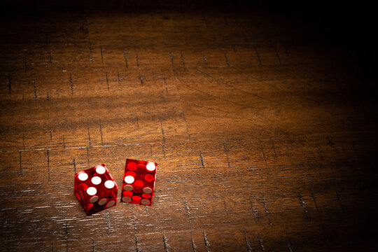 Professional casino-style dice on a wooden table with room for copy. 