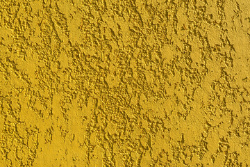 Close-up, texture of a yellow house facade wall made of decorative plaster.