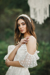 A young cute girl in a white dress poses beautifully. Positive attitudeung cute girl in a white dress poses beautifully. Positive attitude