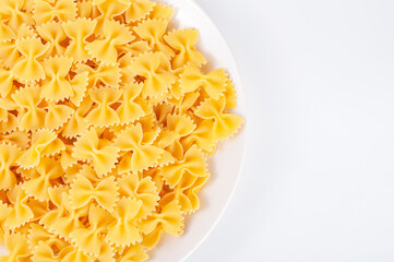 Uncooked pasta farfalle in dish with copyspace