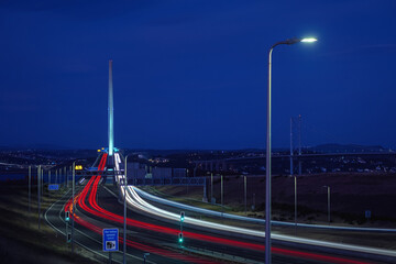 Highway leading to the big bridge and lights from cars at night. Queensferry Crossing, Scotland,...