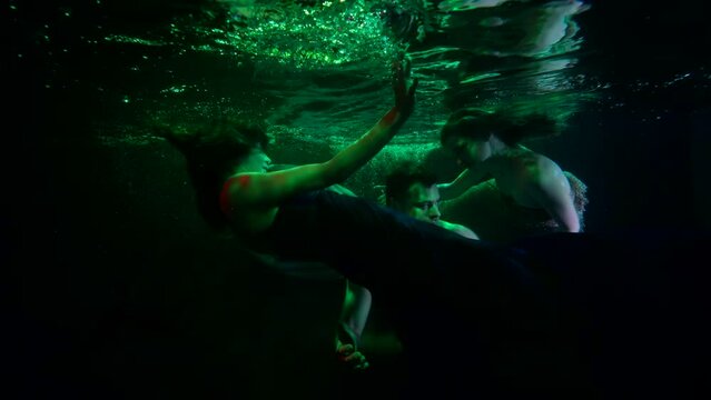 beautiful undines are tempting drowned person, mysterious underwater shot, green light