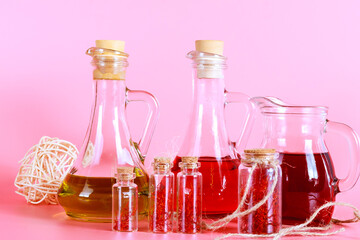 Saffron stamens in small jars and saffron stamen drinks on a pink background.