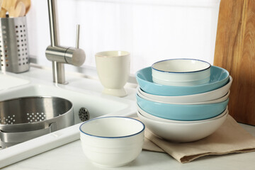 Fototapeta na wymiar Bowls and different cooking utensils near sink in kitchen