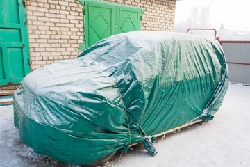 Car covered in winter. Sheltered car in winter. Tent for the car.