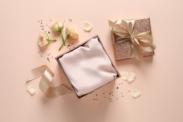 Open gift box, confetti and roses on pink background, flat lay.