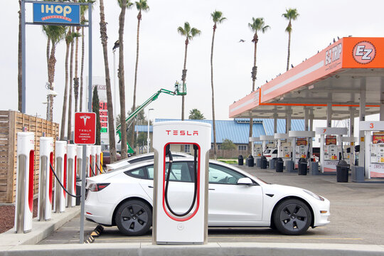 Bakersfield, CA - Jan 29, 2022:  Tesla Supercharger station next to petrol gas station on the Stockton Hwy. Supercharger stations allow Tesla cars to be fast-charged at the network within a hour.