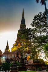 Fototapeta premium Two pagodas with yellow robes tied in the middle of them. This picture was shot when the sun is setting. This picture can be used for traveling concepts or any other concept that you'd like.