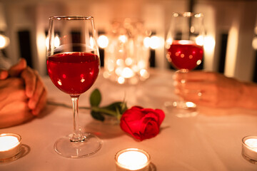 Couple on a restaurant date, dinner setting with rose and candle light 