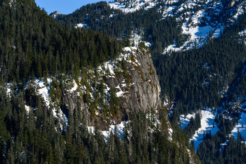 First light on a rock face in the Alpine Lakes Wilderness on a clear blue sunny day, as a nature background
