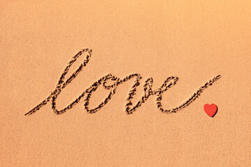 Love, and red heart written in the sand 