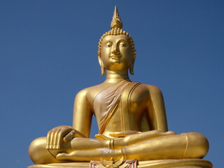 Golden Buddha Statue soars into blue sky