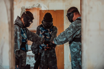Obraz premium The paintball team agrees on tactics before the fight begins. Selective focus