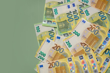 One and two hundred euro banknotes on a green background.Money and finance.Finance and savings.