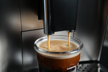 Espresso machine pouring coffee into glass, closeup