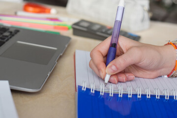 Closeup young girl student hand writing in notebook