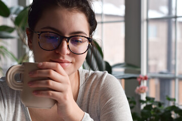 Closeup young girl smiling holding cup of tea or coffee