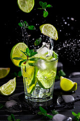 Preparation of cocktail drink known as mojito with alcohol, fresh mint, lemon juice, soda, sugar and ice. Cuban national drink.
