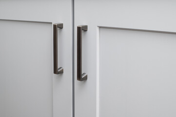 Handles on the doors of the kitchen cabinet white