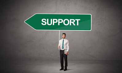 Young business person in casual holding road sign