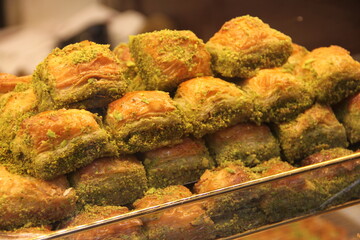 colorful delicious baklava dessert on counter of shop, grocery, market, cafe - close up view. Dessert, sale, sweet food and confectionery concept