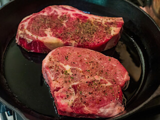 Close up shot of frying aged ribeye steak in a cast iron pan