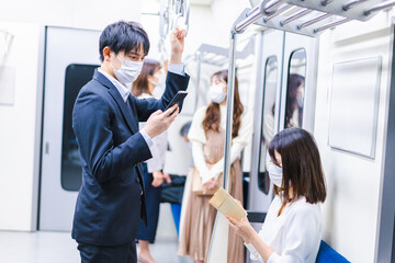 Fototapeta na wymiar マスクをして電車に乗る人々