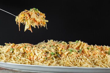 Spoon with Chicken salad. Salpic&atilde;o is a typical Brazilian salad, made with shredded chicken, raisin, grated carrot, potato sticks and mayonnaise.