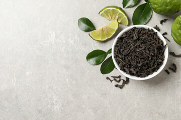 Dry bergamot tea leaves and fresh fruits on light grey table, flat lay. Space for text