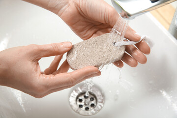 Woman pouring water onto pumice stone in bathroom, above view - obrazy, fototapety, plakaty