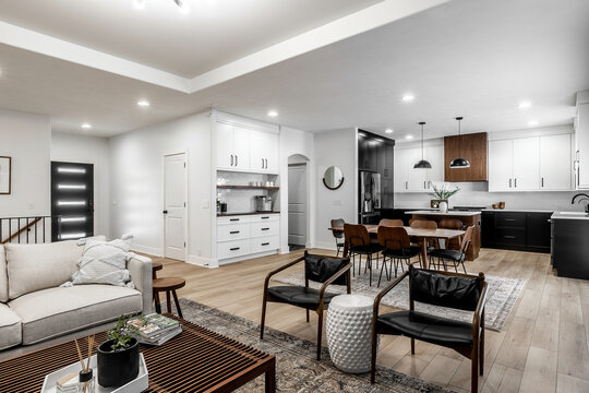 Midcentury modern kitchen with black and white cabinets, matte black fixtures, white quartz countertops and backsplash and walnut wood furniture interior design