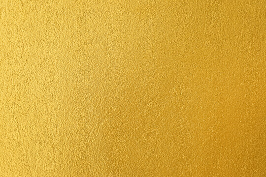 Gold wall texture abstract background, plastered wall painted gold color