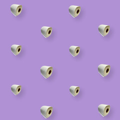 Colorful pattern of rolls of a white toilet paper isolated on purple background. Top view....